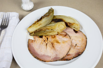 roast pork and braised endives on a plate