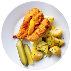 Top view of Parmesan breaded chicken with potatoes, pickles