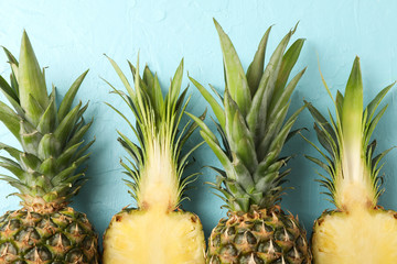 Top of pineapples on blue background, close up. Juicy fruit