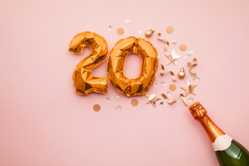 Happy 20th anniversary party. Champagne bottle with gold number balloon.