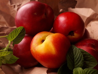 Melocotón fresco con hojas de menta sobre papel madera arrugado