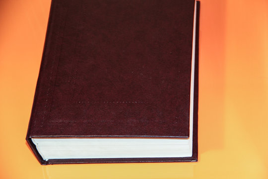 thick book on orange background