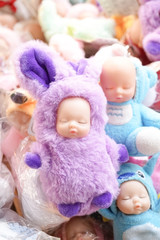 Piles of Toy. Soft focus on the sleeping baby in purple fluffy bunny outfit.