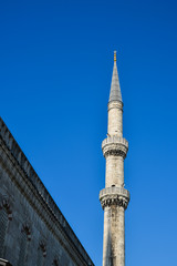 Fototapeta na wymiar A tall white minaret of a Muslim mosque