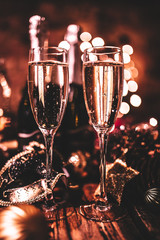 New Year’s Eve celebration with bottles and glasses of champagne. Masquerade themed party. Concept of celebration and luxury lifestyle.