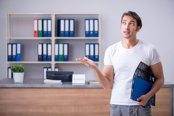 Fototapeta premium Young man at hospital reception desk