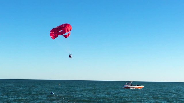 Parasailing in Turkey as a red parachute pulled by a boat was about to land on the water at sunset