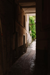 The dark arch in the Italian house. Typical Italian narrow street.