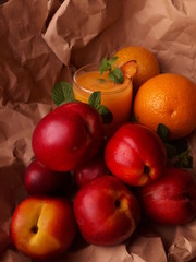 Melocotones y naranjas sobre un fondo rustico de papel madera