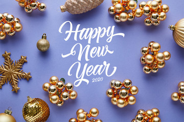 top view of shiny golden Christmas decoration on blue background with happy new year lettering