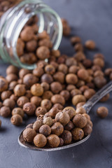 fresh spicy peppers allspice on a dark stone background