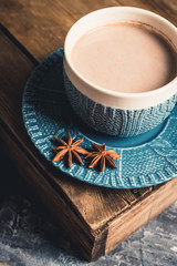 Cup of hot chocolate in winter decorations on the rustic background. Selective focus. Shallow depth of field.