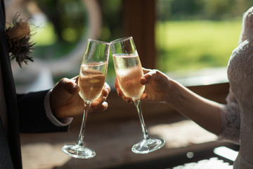 Romantic dinner or date with champagne glasses. Toast and clinking with alcoholic drinks. Celebration on wedding party. Marriage concept