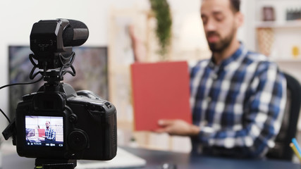 Creative young man recording a book review