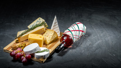 Obraz na płótnie Canvas Different sorts of cheese. Cheese platter with different cheese, and spices on dark background. Top view, wiht copy space