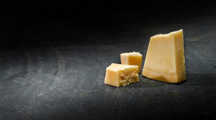Delicious dutch cheese on dark background. Copy space