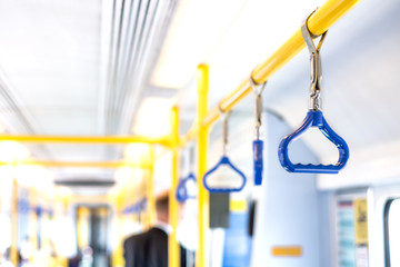 Blue triangles hanging on handrail inside metro carriage
