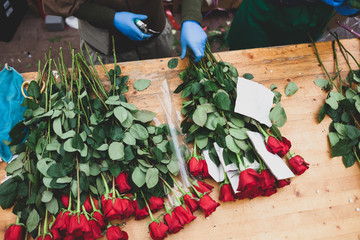 Red roses are on the counter in the flower shop.