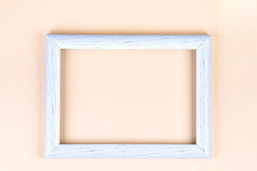 Distressed white painted picture frame, isolated on beige, copy space