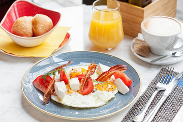 Delicious breakfast with eggs and bacon served in restaurant