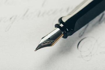 Fototapeta premium Fountain pen on an ancient handwritten letter. Old story. Retro style.