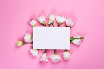 Paper sheet made of eustoma flower on pink background, flat lay. Floral decorative card