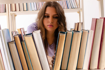 Young female student preparing for exams at library