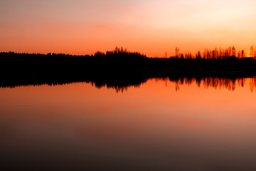 Fototapeta premium sunset on the lake. clouds reflected in the water