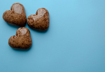 Valentine's flat lay with love chocolate gingerbread heart on colorful blue background, greeting card copy space top view. The celebration of Valentine's Day.