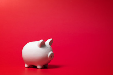 Composition with piggy bank isolated on red background.