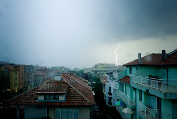 Lightning strike over dark blue sky in night city