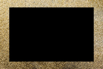 A rectangular, golden glitter frame on a black surface. Christmas, new year, birthday, special occasions background, with a copy space.