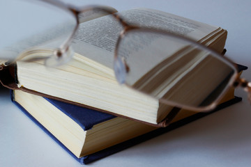 glasses and books on isolated white background