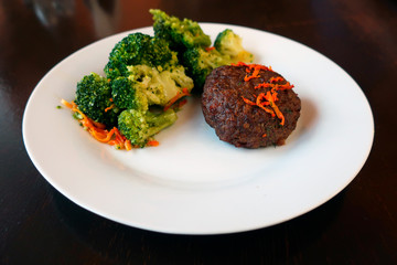 meat cutlet with broccoli and carrots on a plate