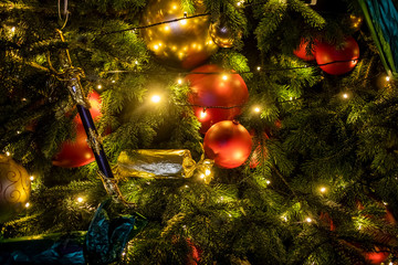 Fototapeta na wymiar texture fir branch with lights and decorations toys. a fragment of the New Year and Christmas tree. close-up, soft focus, blur background