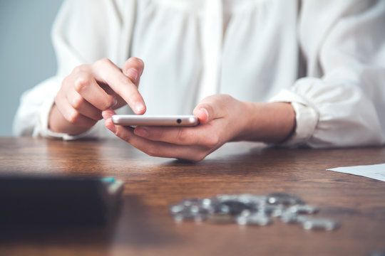 Woman Hand Smart Phone With Coins And Calculator