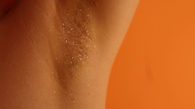 Close up body hair with pink glitter. Body positive concept. Woman beauty. Woman with hairy armpit. Depilation. Woman rights