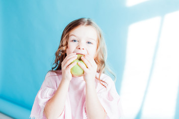 beautiful little girl eating a Green Apple fruit