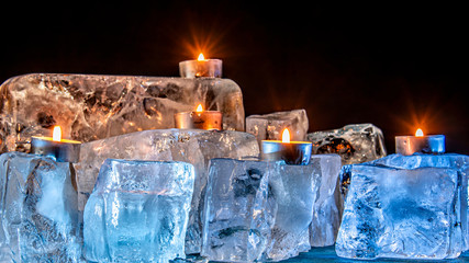 Burning candle among the ice