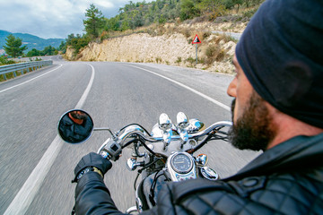 Man riding motorcycle and travelling on an empty country road. 