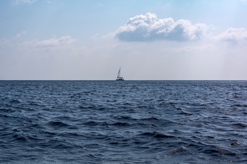 Sailboat in the Mediterranean sea ay horizon. Mediterranean sea scene.