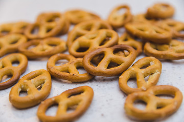 Pretzels scattered over light stone countertop. Snacks for the beer. German traditional snack. Selective focus.