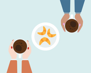 Hands holding cups of coffee. Top view of couple at the table