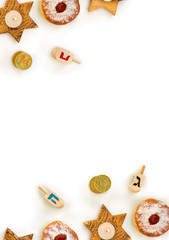 Fototapeta na wymiar Wooden candlesticks in the shape of star, donuts, golden chocolate coins and wooden dreidels on white background with space for text. Jewish holiday Hanukkah. Top view, flat lay