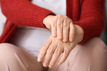 Senior woman suffering from pain in wrist at home, closeup