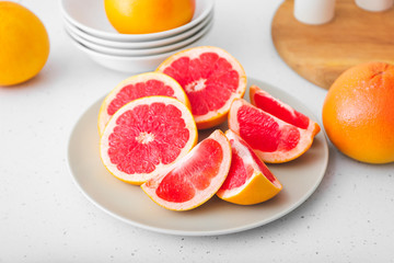 Fototapeta na wymiar Plate with fresh cut grapefruit on table
