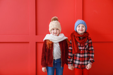 Fototapeta premium Cute little children in winter clothes on color background