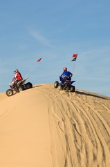 Men Riding Quad Bikes On Sand Dune In Desert