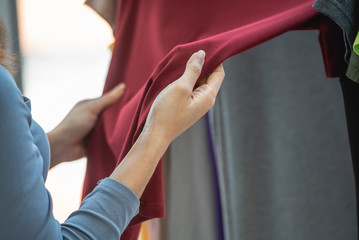 Woman hand choosing clothes on hanger in store, Buying clothes at shopping Mall Store.