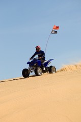 Obraz premium Man Riding Quad Bike In Desert
